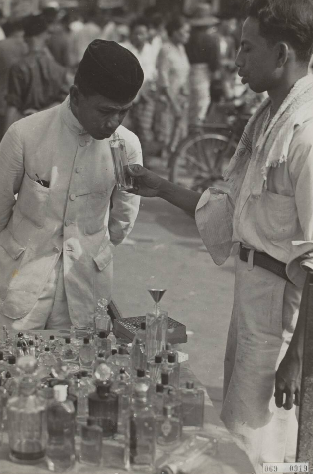 Verkoper van parfum, reukwater en schoonheidsmiddelen op een passer in Indonesië [Jakarta?]